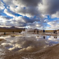 San Pedro de Atacama, Chile - october 14, 2019: people watch amazing El Tatio geysers at sunrise , near San Pedro de Atacama, Chile.